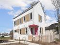 Charming two-story home with white siding, contrasting trim, pink door, and a cute picket fence at 220 N Beville Ave, Indianapolis, IN 46201