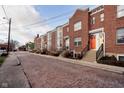 Row of brick townhouses on a cobblestone street at 310 E 10Th St, Indianapolis, IN 46202