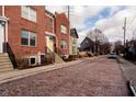 Brick townhouse with yellow door on cobblestone street at 310 E 10Th St, Indianapolis, IN 46202