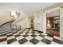 Elegant foyer with black-and-white checkered flooring, a curved staircase, and decorative wall panels at 4601 N Legacy Dr, Muncie, IN 47304