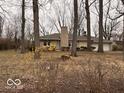 Ranch style home features a stone chimney and two-car garage nestled among mature trees at 4621 E 37Th St, Indianapolis, IN 46218