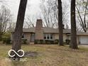 Charming single-story home featuring a stone chimney and mature trees in a peaceful residential setting at 4621 E 37Th St, Indianapolis, IN 46218