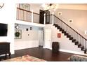 Open living area with loft, hardwood floors, and a wooden staircase at 7571 S County Road 825 E, Plainfield, IN 46168