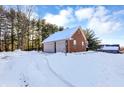 Attached brick garage with double doors, covered in snow at 125 Chalet Dr, Mooresville, IN 46158