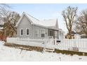 Gray sided house with white picket fence and snowy yard at 1430 St Paul St, Indianapolis, IN 46203