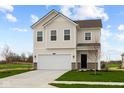 Well-manicured lawn complements the two-story home with a white exterior and a convenient attached garage at 1845 James Pierce Dr, Shelbyville, IN 46176