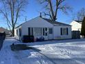 White ranch house with a snow-covered front yard and driveway at 2301 S Vine St, Muncie, IN 47302