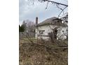 White house with overgrown yard and fence at 2364 Shelby St, Indianapolis, IN 46203