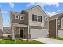 Inviting two-story home featuring gray siding, white trim, and a convenient two-car garage at 5123 Rolling Meadow Blvd, Indianapolis, IN 46237