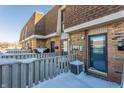 Brick townhouses with a wooden fence, covered in snow at 7421 Country Brook Dr, Indianapolis, IN 46260