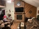 Cozy living room with brick fireplace, wood paneling, and comfortable seating at 7569 Farm View E Cir, Indianapolis, IN 46256