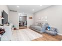 Playroom with gray sofa and view of dining area at 7802 Hardwick Pl, Fishers, IN 46038