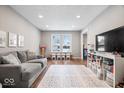 Gathering room with gray sofa and built-in shelving at 7802 Hardwick Pl, Fishers, IN 46038
