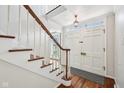 Bright foyer with hardwood floors, white staircase, and classic front door at 7830 Ridgeland Dr, Indianapolis, IN 46250