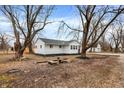 Spacious backyard featuring mature trees, a small patio area, and ample room for outdoor activities at 8810 Beechwood Ave, Indianapolis, IN 46219