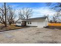 Angle view of a charming single-story home with white siding, updated landscaping, and an attached one-car garage at 8810 Beechwood Ave, Indianapolis, IN 46219