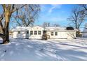 Newly renovated white house with a snow covered front yard at 8810 Beechwood Ave, Indianapolis, IN 46219
