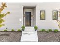 Modern front entrance with black door, neutral siding, and potted plants at 1219 E 15Th St, Indianapolis, IN 46202