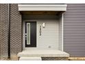 Contemporary townhome entrance with black door and gray siding at 1302 English Ave, Indianapolis, IN 46203