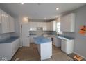 Modern kitchen with white cabinets, gray countertops, and an island at 16775 Cheddar Dr, Noblesville, IN 46060