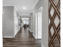 Long hallway with dark hardwood floors and access to other rooms at 19381 Sumrall Pl, Westfield, IN 46074
