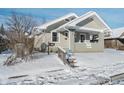 Quaint craftsman home with light green exterior, covered porch, and snowy front yard at 4724 E New York St, Indianapolis, IN 46201