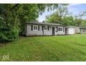 Attractive single-story home with gray siding, a manicured lawn, an attached carport, and mature trees at 5807 Westhaven Dr, Indianapolis, IN 46254