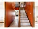 Bright foyer featuring a carpeted staircase, rich wood trim, and a glimpse into the living spaces at 5838 W Bayfield Dr, McCordsville, IN 46055