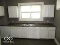 Simple kitchen with white cabinets and dark countertop at 1138 W 33Rd St, Indianapolis, IN 46208