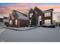 Brick home with a three-car garage, snow covered lawn at 13172 Antonia Blvd, Carmel, IN 46074