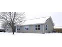 Ranch home, gray siding, blue shutters, snowy yard at 1685 Juniper Dr, Columbus, IN 47201