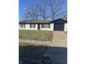 Ranch style home with white brick exterior, black accents, and a grassy lawn at 2450 Morning Star Dr, Indianapolis, IN 46229