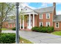 Classic brick home with stately white columns, complemented by lush greenery and a paved driveway at 2940 Washington St, Columbus, IN 47201