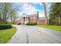 Elegant brick home with a symmetrical facade, prominent white columns, and a sprawling driveway at 2940 Washington St, Columbus, IN 47201