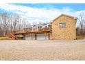 Stone and siding house with a large deck and a three-car garage at 3264 W Roberts Rd, Trafalgar, IN 46181