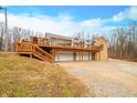 House with large deck, three-car garage, and a sloping yard at 3264 W Roberts Rd, Trafalgar, IN 46181