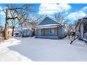 Newly renovated blue house with a covered porch, freshly painted and snow covered yard at 35 S Catherwood Ave, Indianapolis, IN 46219