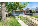 Charming blue home featuring a covered porch with orange pillars and a walkway at 35 S Catherwood Ave, Indianapolis, IN 46219