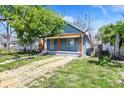 Charming blue home featuring a covered porch with orange pillars and a yard at 35 S Catherwood Ave, Indianapolis, IN 46219