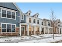 Two-story townhome with front porch, stone accents, and snow-covered landscaping at 3921 Wren Dr, Brownsburg, IN 46112