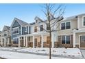 Two-story townhome with front porch, stone accents, and snow-covered landscaping at 3921 Wren Dr, Brownsburg, IN 46112