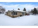 Back exterior of ranch home, snow covered yard at 457 S High School Rd, Indianapolis, IN 46241