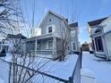 Gray house with a front porch and a snow covered yard at 78 N Belleview Pl, Indianapolis, IN 46222