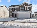 Two-story house with brown siding, white garage door, and snowy front yard at 10115 Redwood Peak Ln, Indianapolis, IN 46259