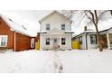 Two-story white house with pink door and walkway, snow on the ground at 1306 E Minnesota St, Indianapolis, IN 46203