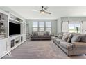 Spacious living room with gray sofas, built-in shelving, and a stone fireplace at 15998 Bugle Ridge Dr, Noblesville, IN 46060