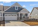 Attractive blue house boasts stone accents, a two-car garage, and a well-maintained driveway at 16673 Cattle Hollow Ln, Noblesville, IN 46060