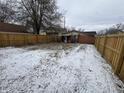 Large backyard with wooden fence and light snow cover at 1801 W Morris St, Indianapolis, IN 46221