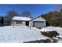 Snow covered ranch home with gray garage and stone accents at 3332 Lauren Dr, Indianapolis, IN 46235