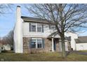 Two-story house with vinyl siding, brick accents, attached garage, and landscaping at 504 Grand Woods Dr, Indianapolis, IN 46224